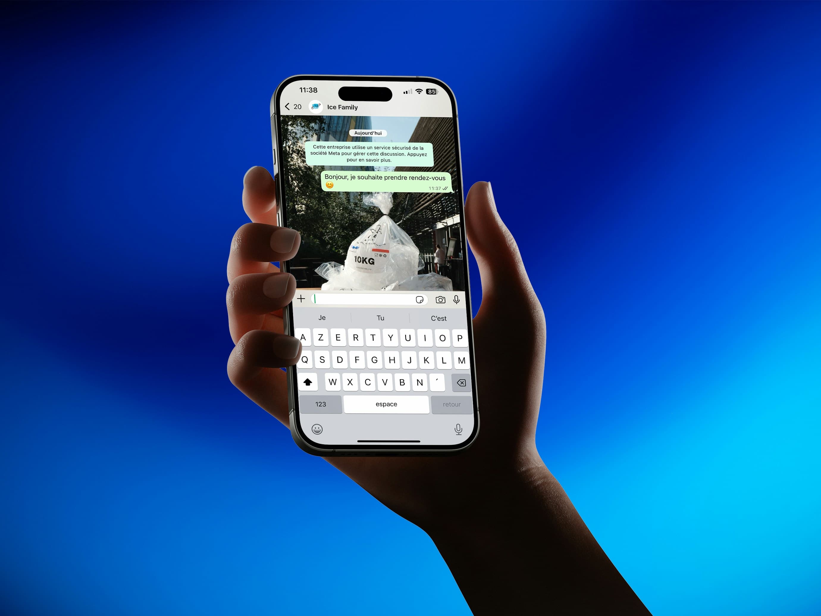 Hand holding a smartphone with an open WhatsApp chat